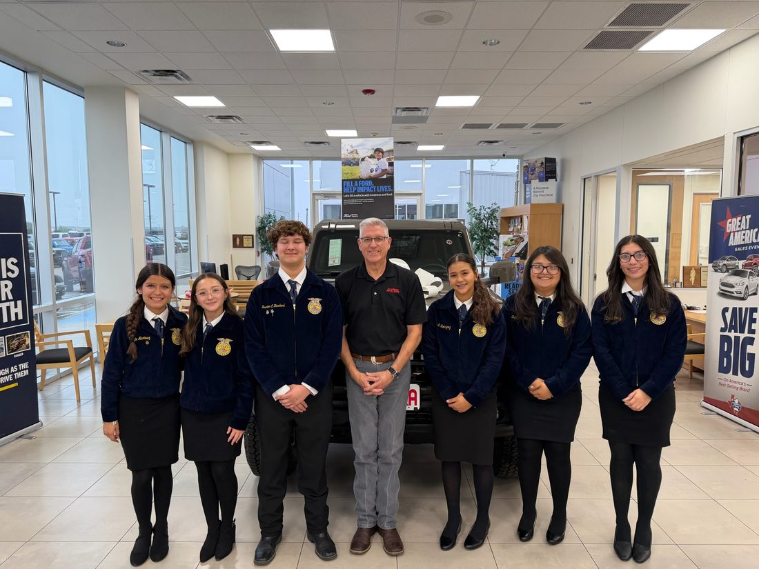 Local FFA students in their corduroy jackets with an Ancira team member in the showroom